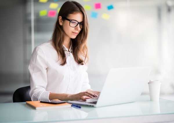 successful-businesswoman-working-laptop-computer-her-office-dressed-up-white-clothes